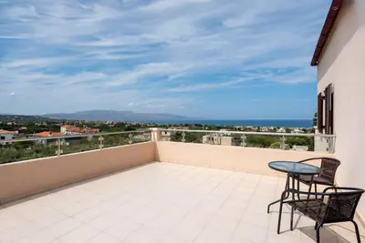 a balcony with two chairs and a table at Villa Stratianna by PosarelliVillas in Módhion