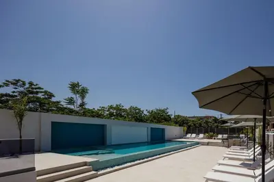 an outdoor swimming pool with an umbrella and chairs at Aurora apartments in Chania Town