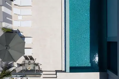 an overhead view of a swimming pool with a umbrella at Aurora apartments in Chania Town