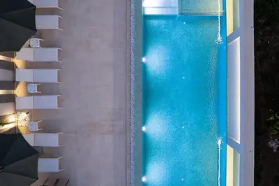 an overhead view of a swimming pool with an umbrella at Aurora apartments in Chania Town