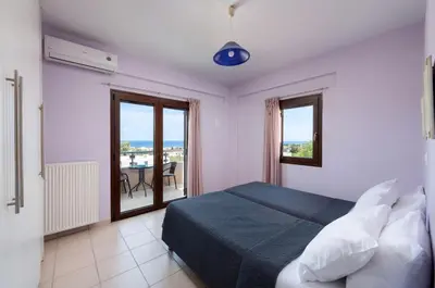 a bedroom with a bed and a balcony at Villa Flora by PosarelliVillas in Módhion