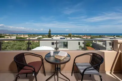 a balcony with a table and chairs and a view at Villa Flora by PosarelliVillas in Módhion