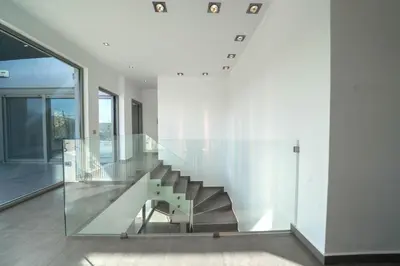 a staircase in a house with a glass wall at La Maison Du Soleil Luxury Villa by 8essentially in Varípetron