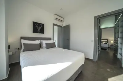 a bedroom with a large white bed in a room at La Maison Du Soleil Luxury Villa by 8essentially in Varípetron