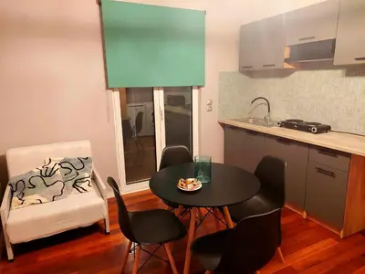 a kitchen with a table and chairs and a table and a chair at Art and view-studio in Kounoupidhianá