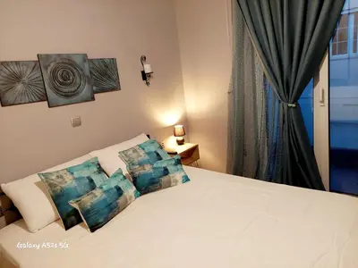 a bedroom with a white bed with pillows at Art and view-studio in Kounoupidhianá
