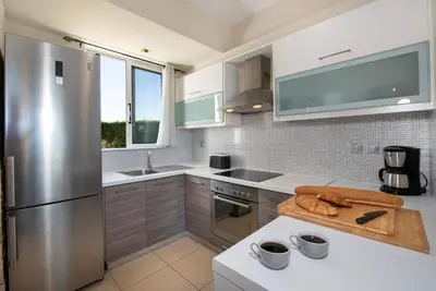 a kitchen with white counters and stainless steel appliances at Gabriel apartment with a shared pool close to the beach in Chorafakia