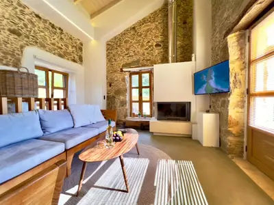 a living room with a blue couch and a table at The Stone House - Two Bedrooms Maisonette in Avdhoulianá