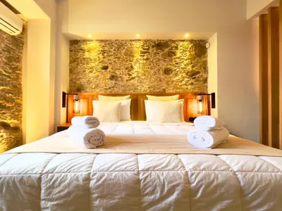 a bedroom with a large bed with towels on it at The Stone House - Two Bedrooms Maisonette in Avdhoulianá