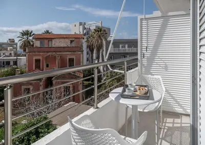 a balcony with a table and chairs on a balcony at West City Suite in Chania Town