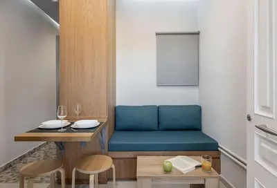 a dining room with a blue couch and a table at West City Suite in Chania Town