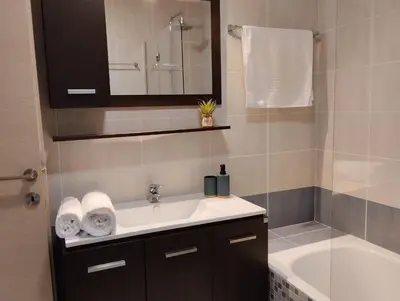 a bathroom with a sink and a tub and a mirror at Zoe's Luxury Home - Private Parking in Chania Town
