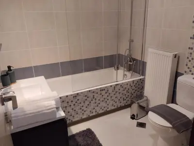 a bathroom with a tub and a toilet and a sink at Zoe's Luxury Home - Private Parking in Chania Town