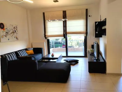 a living room with a black couch and a table at Zoe's Luxury Home - Private Parking in Chania Town