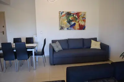 a living room with a couch and a table with chairs at Zoe's Luxury Home - Private Parking in Chania Town