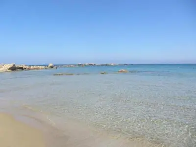 a beach with the ocean and rocks in the background at Sky & Sea 2 in Kato Daratso