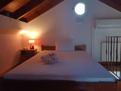 a bedroom with a large white bed with a window at Sky & Sea 2 in Kato Daratso
