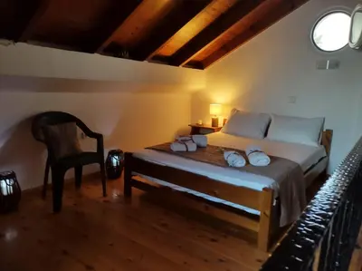 a bedroom with a bed and a chair in a room at Sky & Sea 2 in Kato Daratso