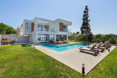 a large villa with a swimming pool and lawn at Avra & Ostria Villa, Pirgos-Villas,Heated pool , amazing sea view in Maleme