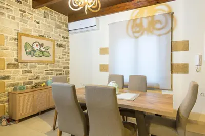 a dining room with a wooden table and chairs at Villa Drapanias Homeleader in Drapaniás