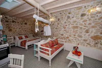 a bedroom with a bed and a couch and a table at Trigono Traditional House in Kalivianí