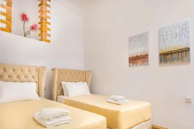 a room with two beds and paintings on the wall at Vener Suites in Chania Town