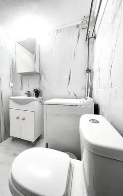 a white bathroom with a toilet and a sink at Odyseia Apts ΙI at the Center of the City & Old Town in Chania Town