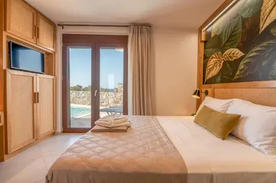 a bedroom with a bed and a sliding glass door at Sia Elafonisi Pool House in Elafonisi