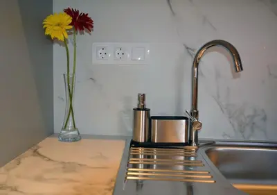 a kitchen sink with a vase with a yellow flower at Cozy Val in Chania Town