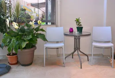 a table and two chairs and a table with plants at Cozy Val in Chania Town