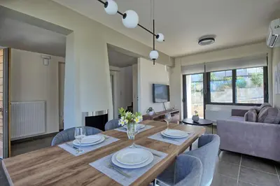 a dining room with a wooden table and chairs at Phaedra by PosarelliVillas in Kounoupidhianá