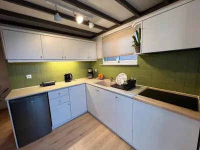 a kitchen with white cabinets and green tiles at m&m's city loft in Chania Town