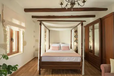 a bedroom with a four poster bed with pink pillows at Nicole Villa I 