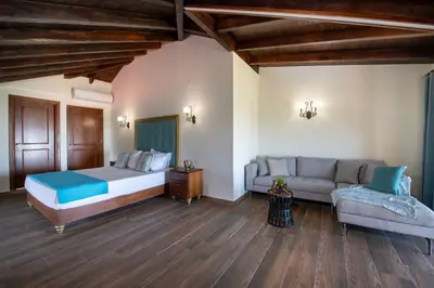 a bedroom with a bed and a couch at Geroulios Kastro Villas I 