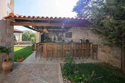 an outdoor kitchen with a wooden counter top in a backyard at Geroulios Kastro Villas I 