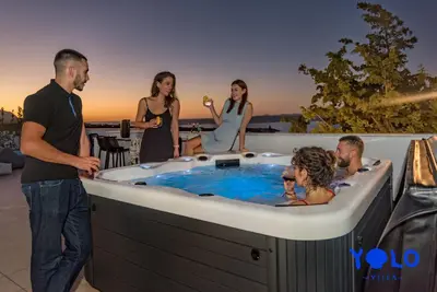 a group of people standing around a hot tub at Villa YOLO in Almirida