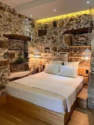 a bedroom with a bed in a stone wall at The Stone House in Avdhoulianá