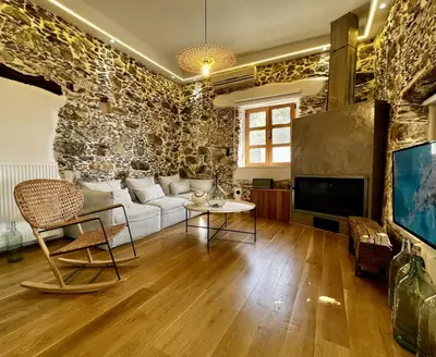 a living room with a couch and a tv at The Stone House in Avdhoulianá