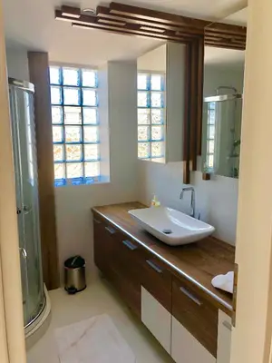 a bathroom with a sink and a large mirror at W Apartment in Chania Town