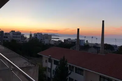 a view of a city with two smoke stacks at sunset at W Apartment in Chania Town