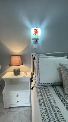 a bedroom with a bed with a lamp and a nightstand at Gesthimani's Residence in Áyios Yeóryios