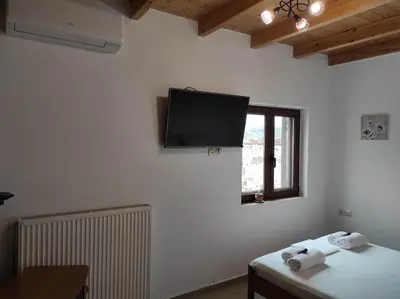 a room with a flat screen tv on the wall at Alexander's cottage in Límni