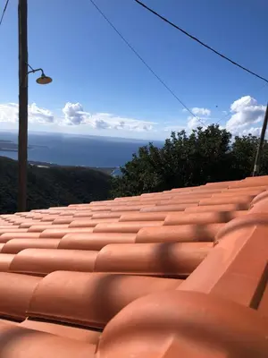 a row of red seats with the ocean in the background at ARETI Sea View Mountain Cottage in AmigdhalokeFálion