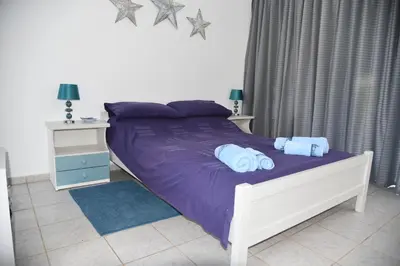 a bed with purple sheets and blue pillows in a bedroom at Relaxing and Comfortable Studio Near Falasarna Beaches in Plátanos