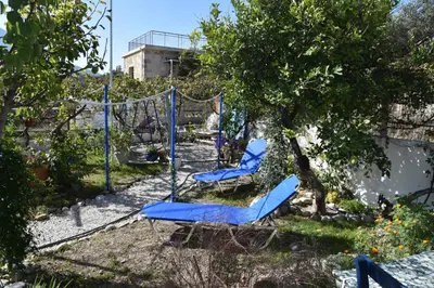 two blue chairs and a swing in a garden at Relaxing and Comfortable Studio Near Falasarna Beaches in Plátanos