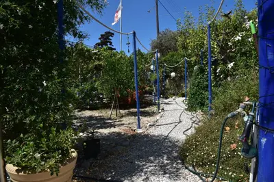 a garden with blue poles and plants on a sidewalk at Relaxing and Comfortable Studio Near Falasarna Beaches in Plátanos