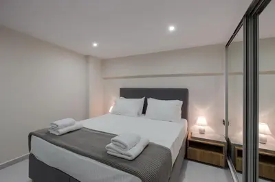 a bedroom with a white bed with towels on it at Home Sweet Home - Big Balcony with Great View in Kissamos