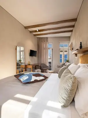 a bedroom with a large bed and a living room at Casa Modiano Boutique in Chania Town