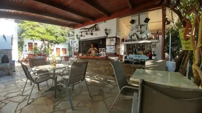 a patio with a table and chairs and a bar at Summer Lodge in Maleme