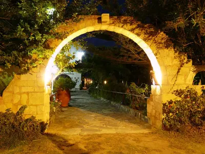 an archway in a stone wall at night at Summer Lodge in Maleme